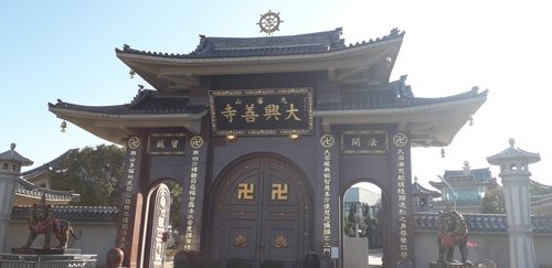 九華山大興善寺正門，圖片中間是寺廟的門樓，兩旁有石獅子雕塑
