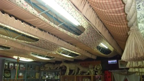 黃金小鎮中的喜妹娜哇稻草藝品館，館內內部多樣的繩條與藝品。圖片上方是由注連繩裝飾而成的天花板，而圖片下方則有一些注連繩編織工藝品，像是編織而成的貓、狗等等