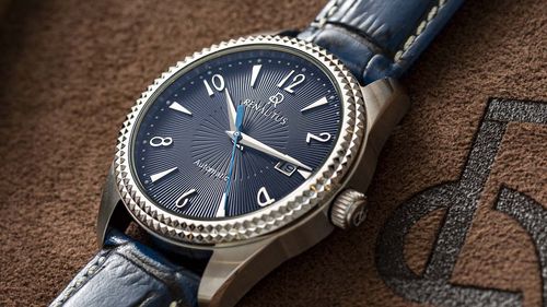 鐳諾塔絲Renautus藍面放射紋手錶，底部為咖啡色皮製布料